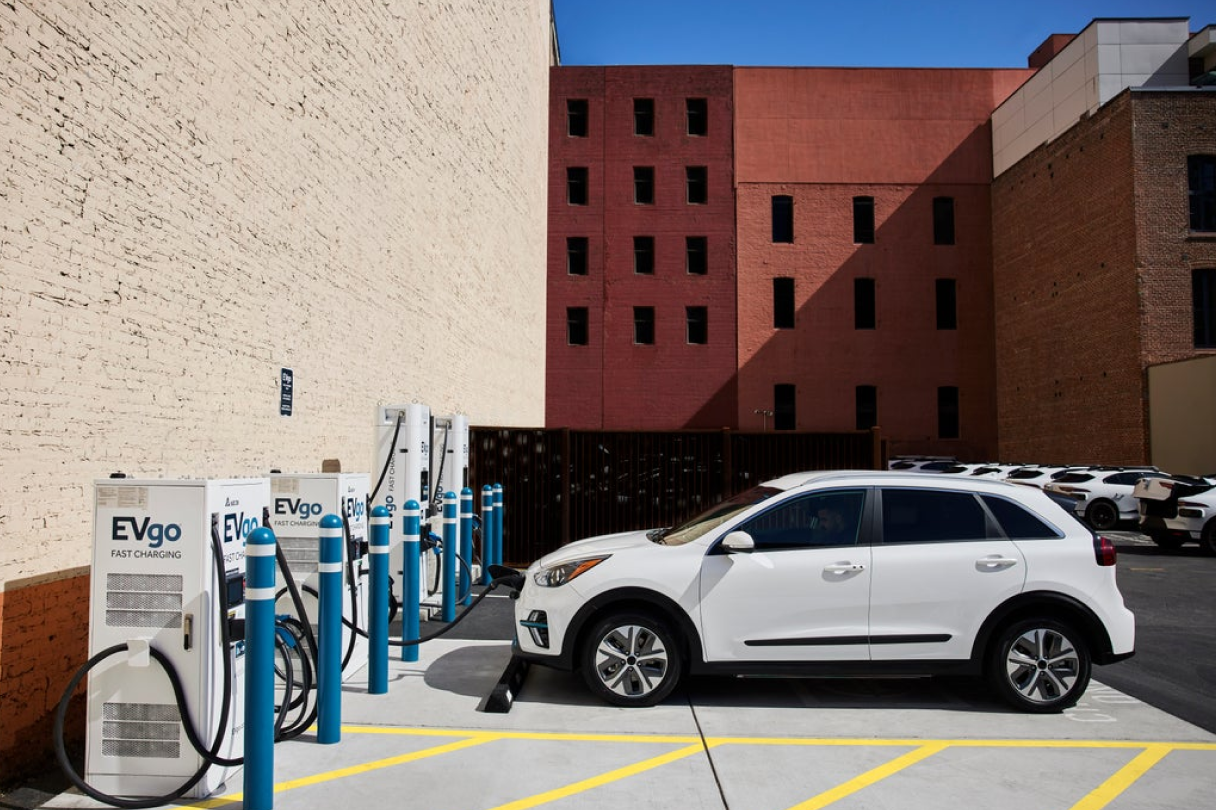 Electric car plugged in at at electric vehicle charging station.